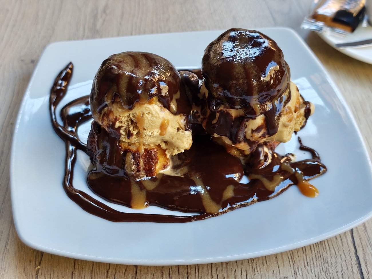 Deux profiteroles de cannelés nappées de caramel au beurre salé, glace vanille.