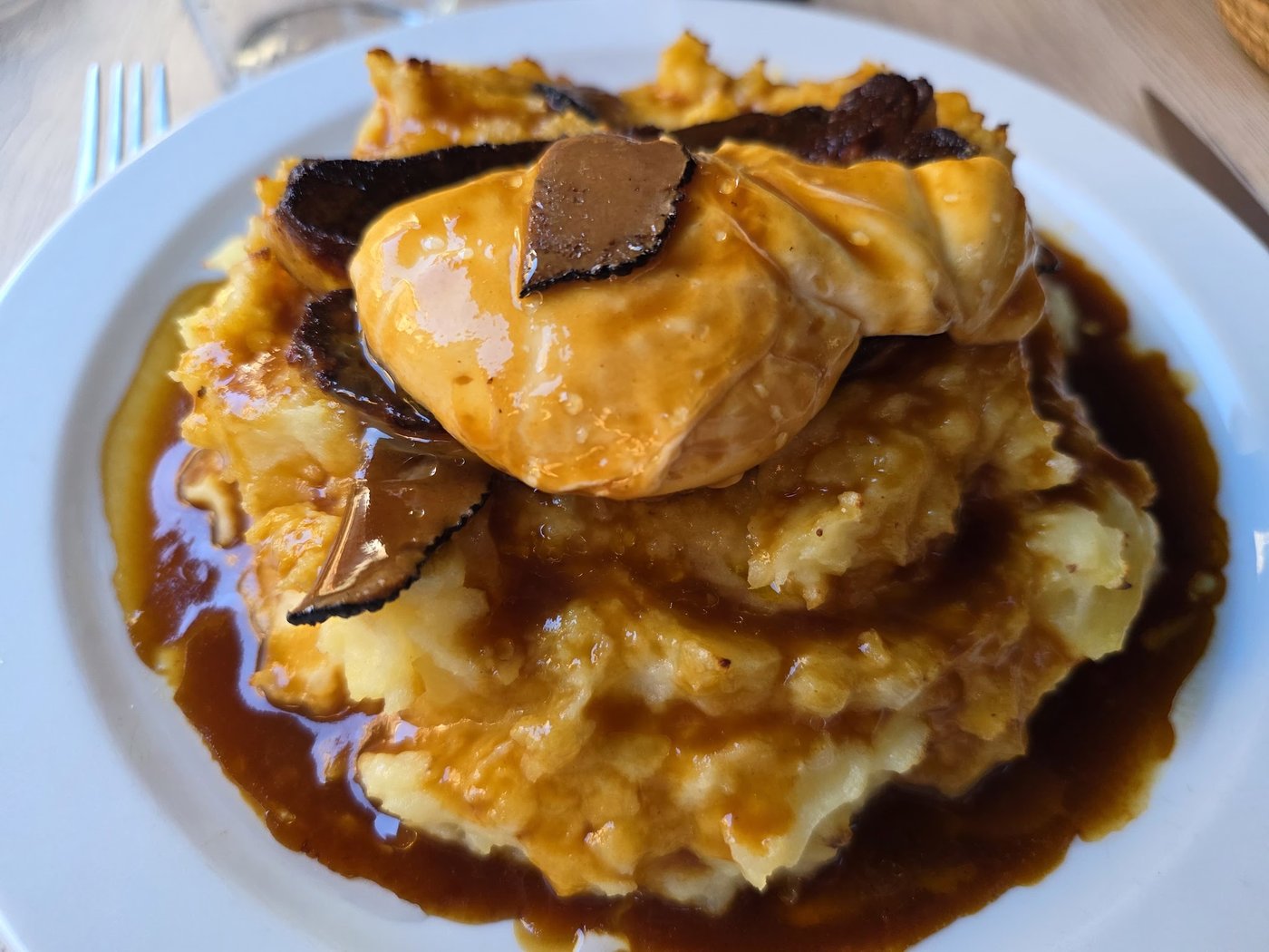 La purée du pauvre : purée nappée de jus, œuf poché, foie gras et lamelles de truffe noire.